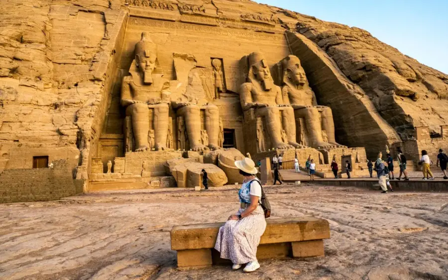 A visitor seated in front of the Abu Simbel temple
